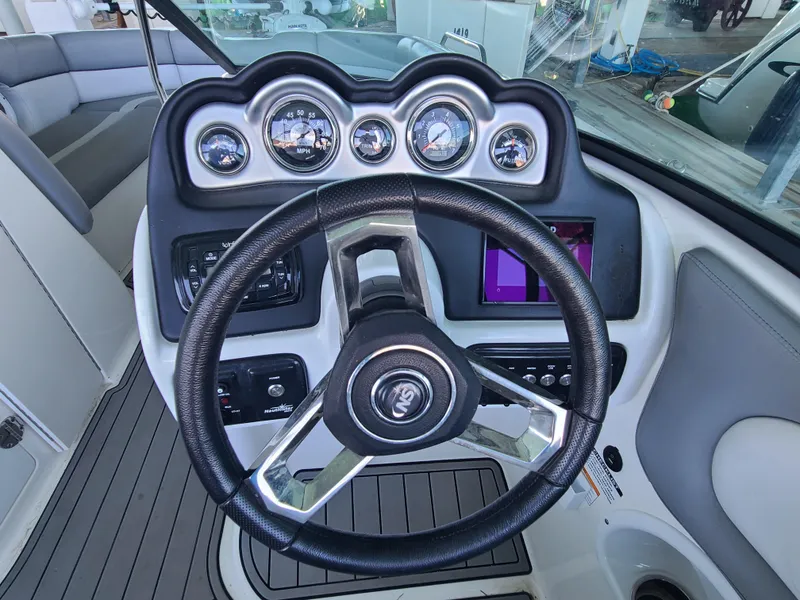 Slide: The Image of 2021 NauticStar 243 DC boat dashboard with steering wheel and gauges. - 12