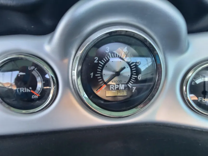 Slide: The Image of Close-up of 2021 NauticStar 243 DC boat dashboard gauges, showing RPM and trim indicators. - 14