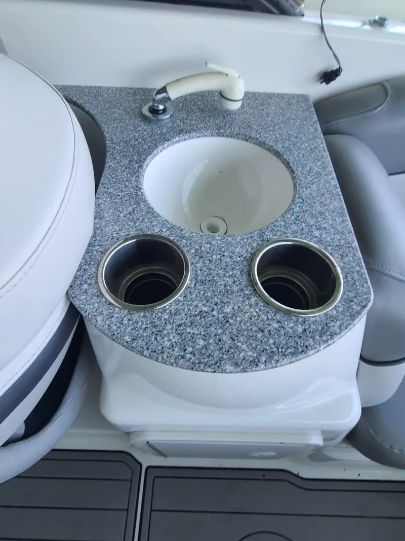 Slide: The Image of 2021 NauticStar 243 DC boat sink with granite countertop and cup holders. - 15