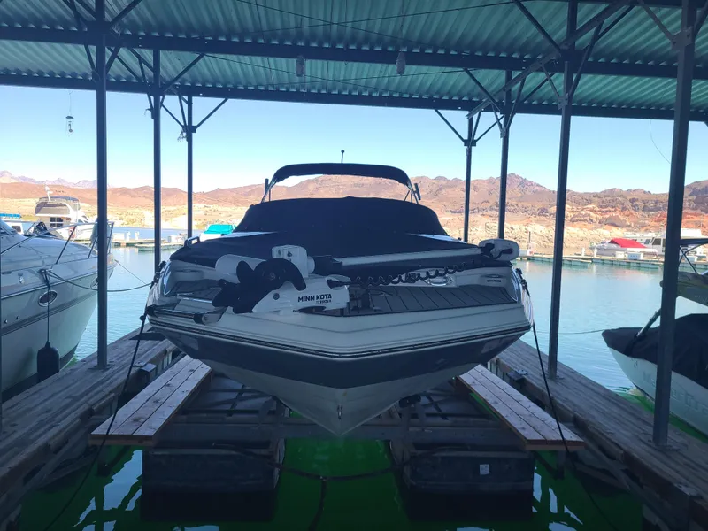 Slide: The Image of 2021 NauticStar 243 DC boat docked under a covered marina. - 3