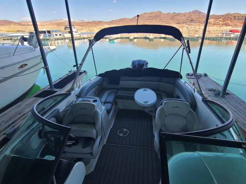 Slide: The Image of 2021 NauticStar 243 DC boat interior at a marina, with seating and table. - 8