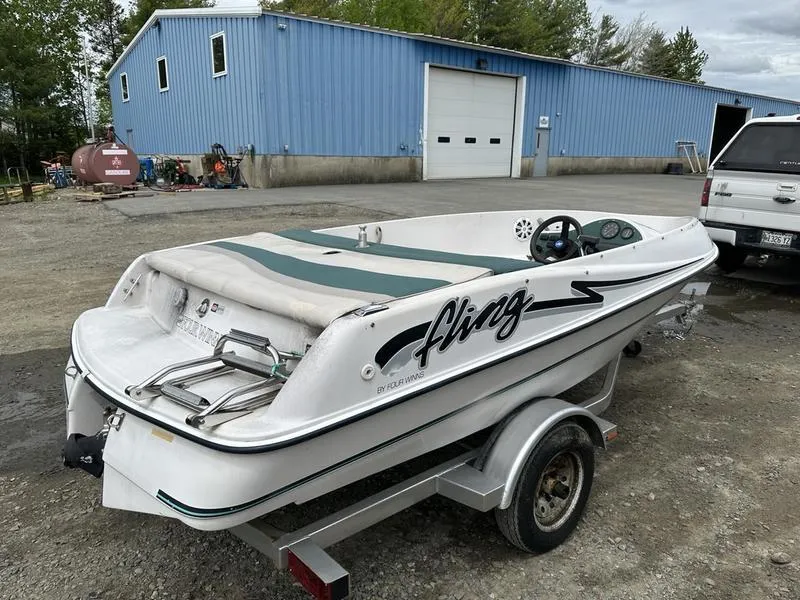 Slide: The Image of 1995 Four Winns Fling boat on trailer near blue warehouse. - 1