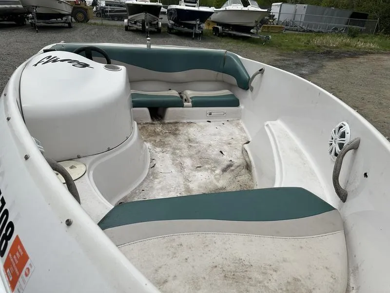 Slide: The Image of 1995 Four Winns Fling boat interior with green and white seating, showing wear. - 4