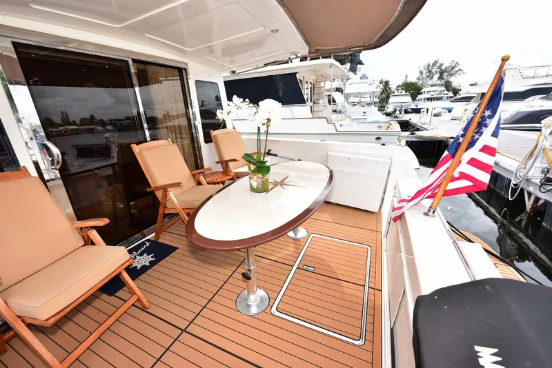 Slide: The Image of Luxurious 2004 Navigator Rival yacht deck with seating, table, and American flag. - 10