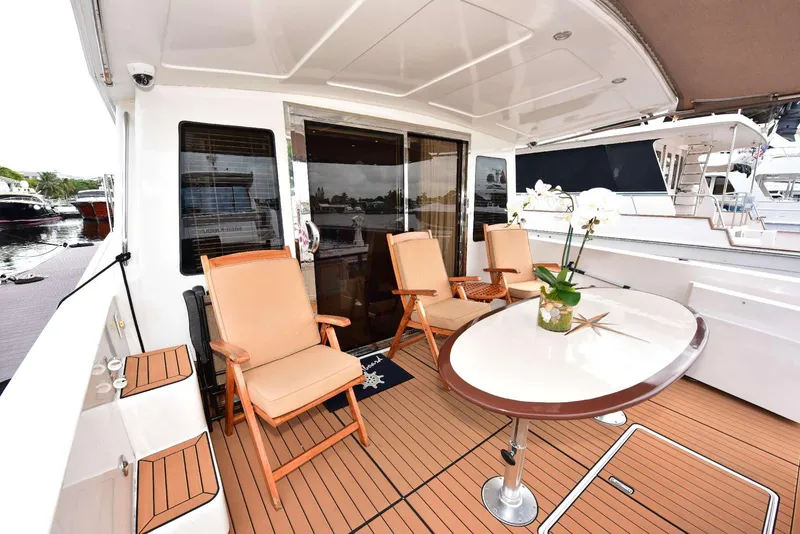 Slide: The Image of 2004 Navigator Rival yacht deck with chairs and table, featuring elegant wood flooring. - 11