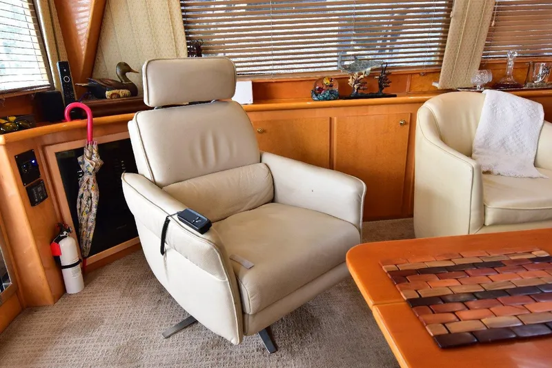 Slide: The Image of Luxurious interior of 2004 Navigator Rival yacht with beige leather chair and wooden accents. - 16