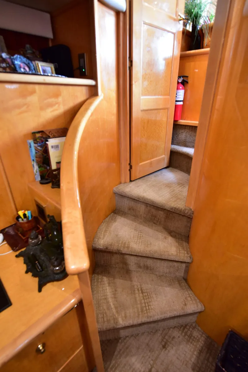 Slide: The Image of Interior staircase of 2004 Navigator Rival yacht with wooden finish and carpeted steps. - 23