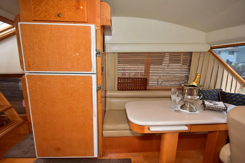 Slide: The Image of Luxurious 2004 Navigator Rival yacht interior with dining area, champagne, and wooden cabinetry. - 35