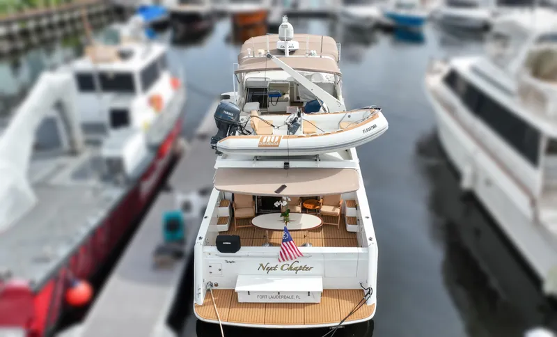 Slide: The Image of 2004 Navigator Rival yacht docked, featuring a small boat on deck, American flag displayed. - 4