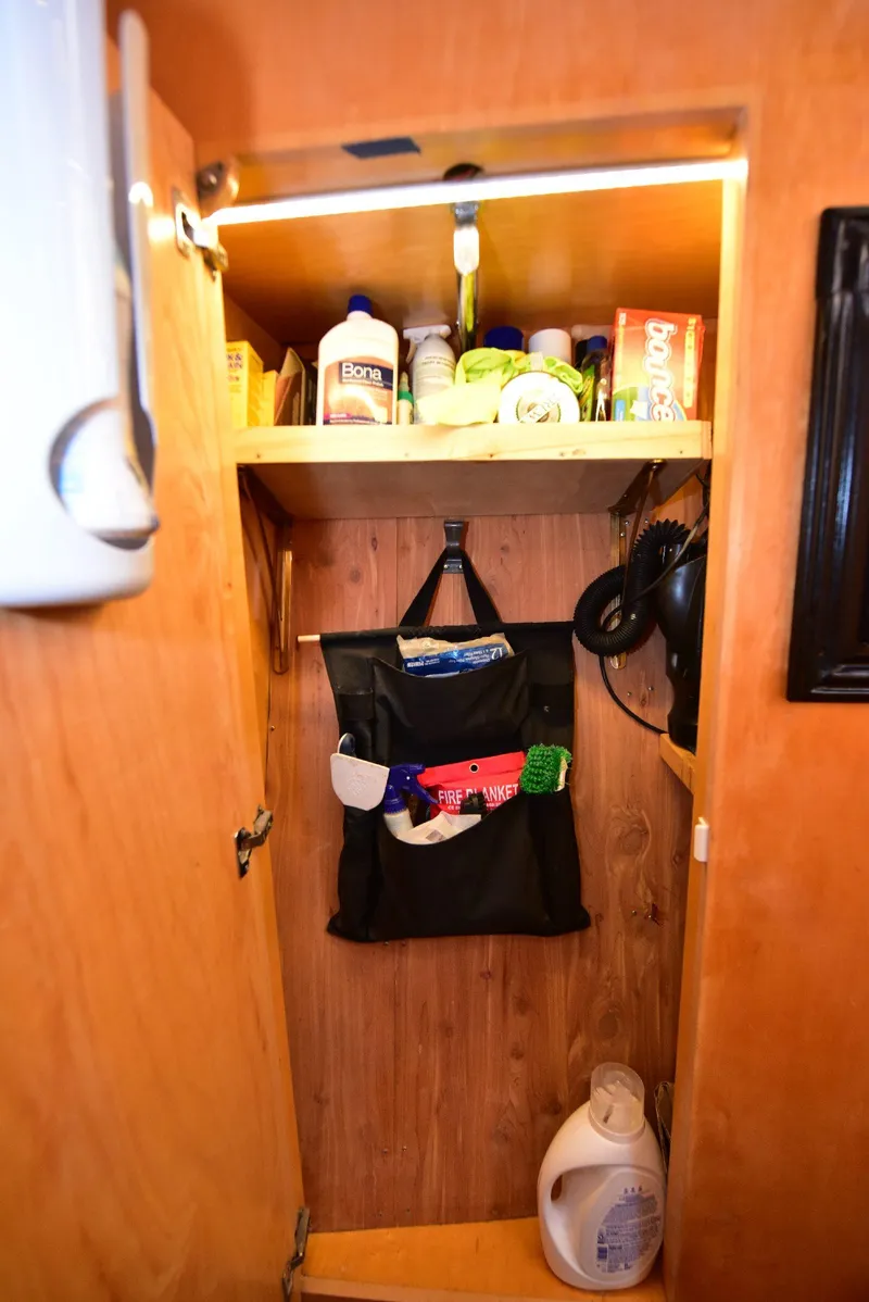 Slide: The Image of 2004 Navigator Rival RV cabinet with cleaning supplies and storage. - 45