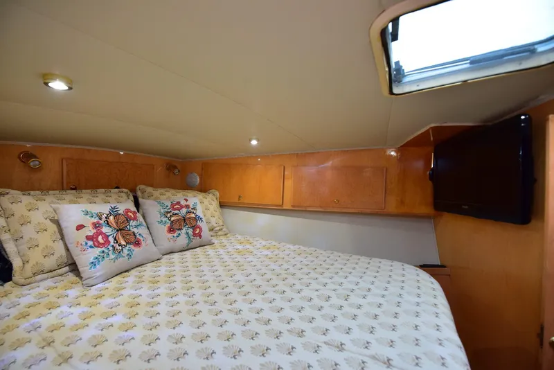 Slide: The Image of Cozy bedroom in 2004 Navigator Rival yacht with floral pillows and wooden cabinetry. - 48