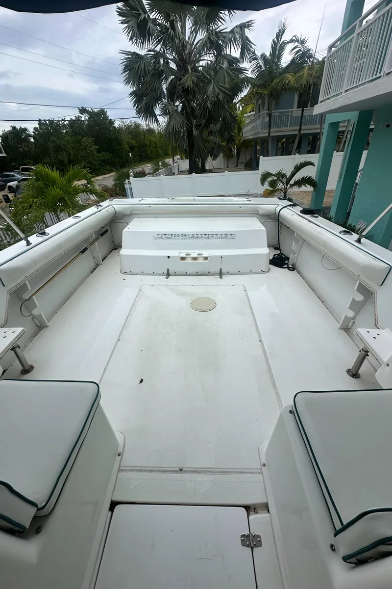 Slide: The Image of 1996 Sport-Craft 272 Sportfish boat deck with seating, surrounded by tropical scenery. - 10