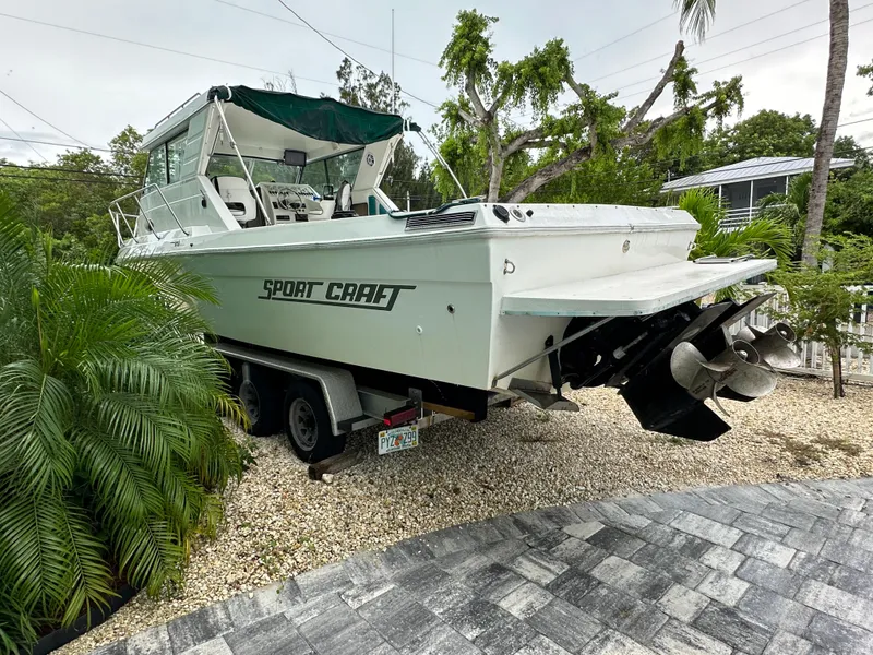 Slide: The Image of 1996 Sport-Craft 272 Sportfish boat on trailer, surrounded by tropical plants. - 5