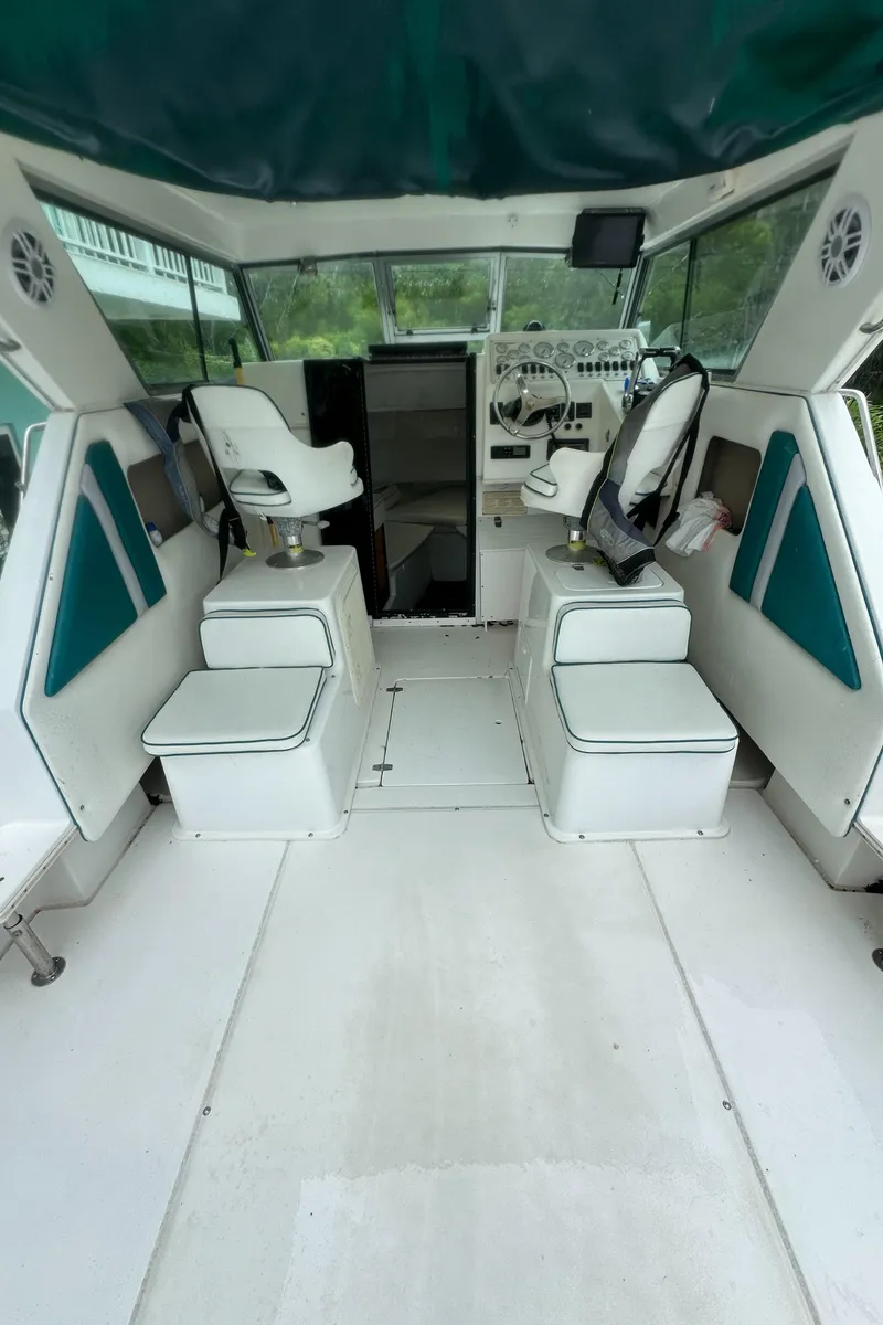 Slide: The Image of 1996 Sport-Craft 272 Sportfish boat interior with seating and steering area. - 7