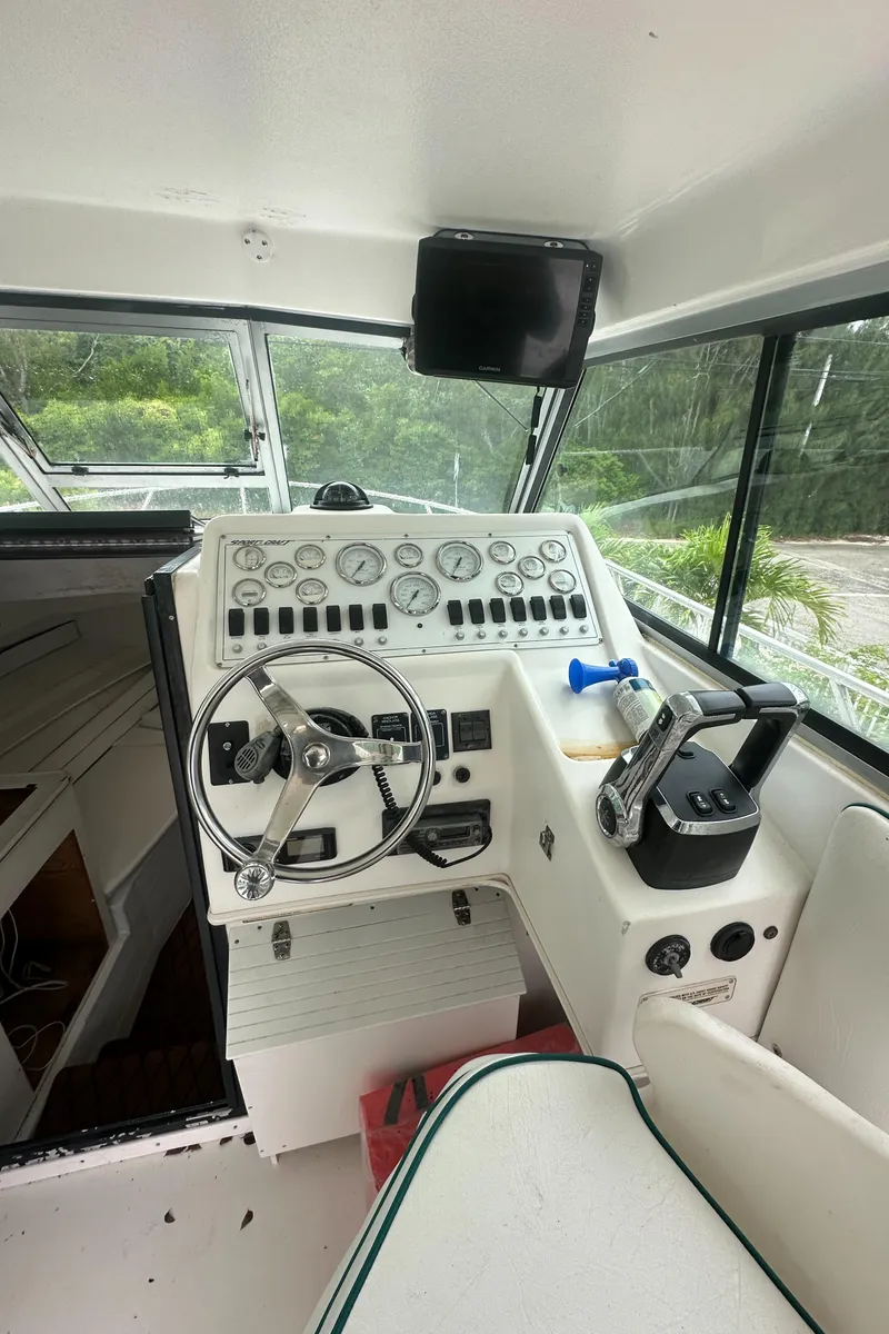 Slide: The Image of 1996 Sport-Craft 272 Sportfish boat helm with steering wheel and control panel. - 8
