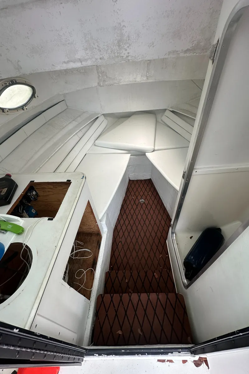 Slide: The Image of 1996 Sport-Craft 272 Sportfish cabin interior with white seating and wooden flooring. - 9