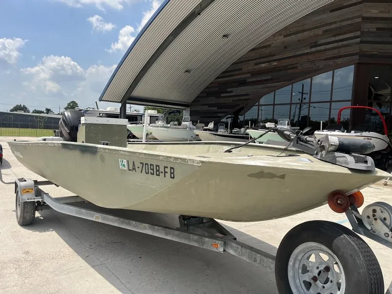 Slide: The Image of Nova 20 boat from 2000 on trailer, parked outside modern building. - 12