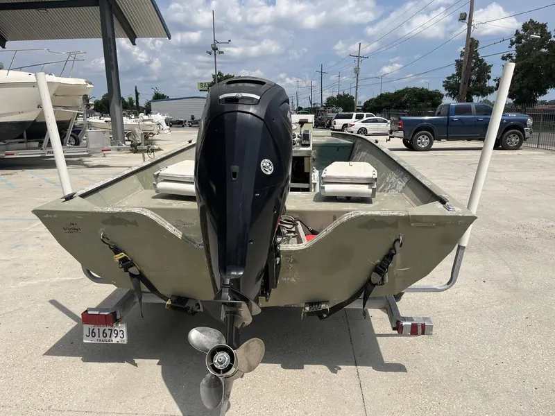 Slide: The Image of Nova 20 boat, 2000 model, with outboard motor, parked on a trailer in a lot. - 13