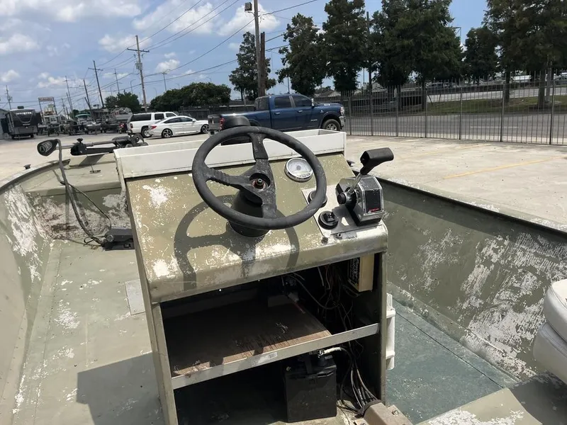 Slide: The Image of Old Nova 20 boat dashboard with steering wheel and controls, parked outdoors. - 6