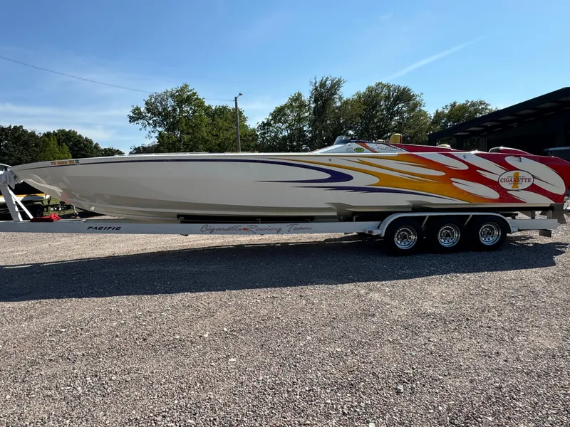 Slide: The Image of 2002 Cigarette 36 Gladiator speedboat with vibrant flame design on trailer. - 11