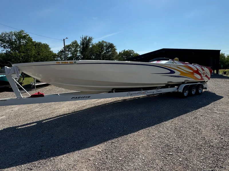 Slide: The Image of 2002 Cigarette 36 Gladiator boat on trailer, vibrant graphics, parked outdoors. - 12