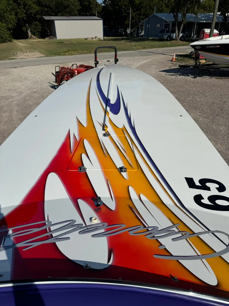 Slide: The Image of 2002 Cigarette 36 Gladiator boat with vibrant flame graphics on deck. - 13