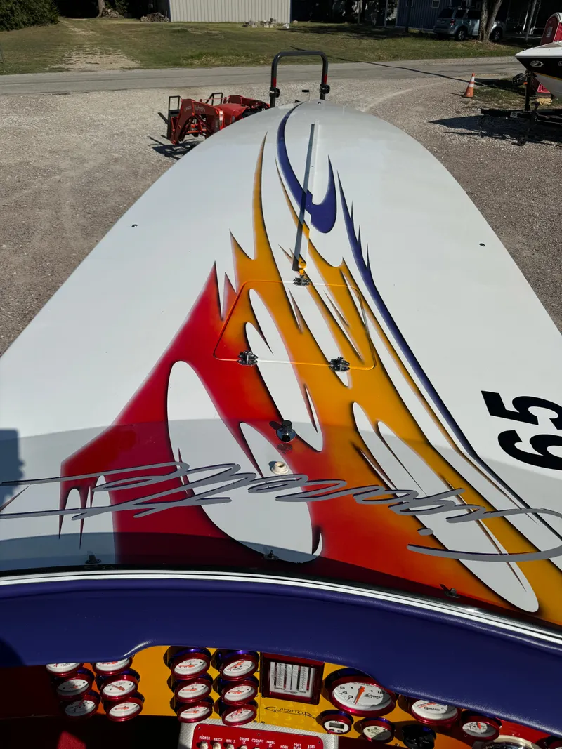 Slide: The Image of 2002 Cigarette 36 Gladiator boat with vibrant flame graphics on deck. - 14