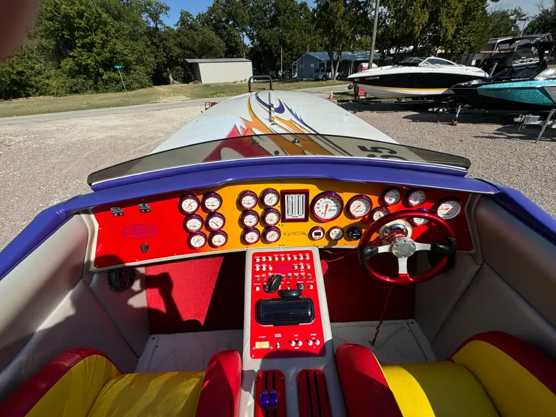 Slide: The Image of 2002 Cigarette 36 Gladiator boat cockpit with vibrant dashboard and steering wheel. - 15