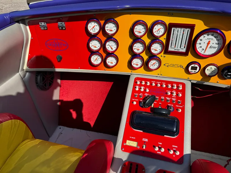 Slide: The Image of Dashboard of a 2002 Cigarette 36 Gladiator boat with colorful gauges and controls. - 17