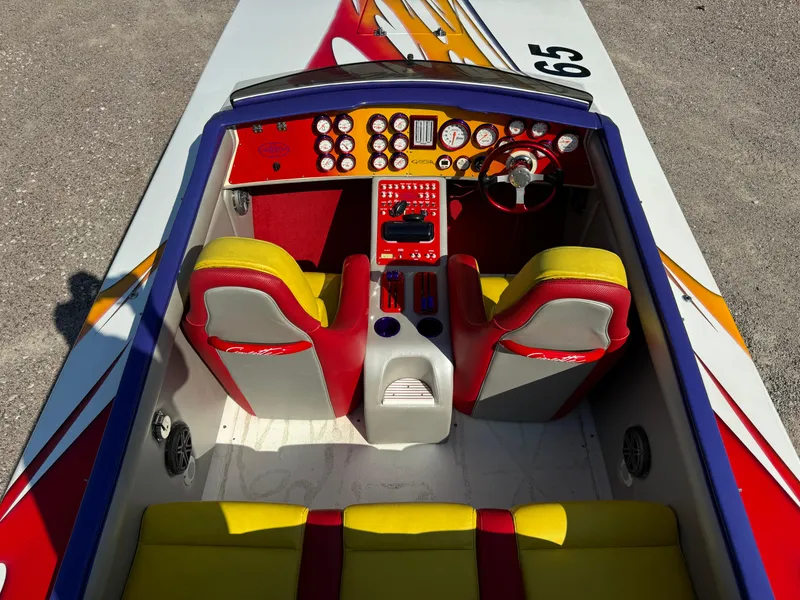 Slide: The Image of 2002 Cigarette 36 Gladiator boat cockpit with vibrant red and yellow seating. - 19