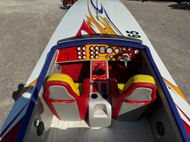 Slide: The Image of 2002 Cigarette 36 Gladiator boat cockpit with vibrant red and yellow seats, detailed dashboard. - 22