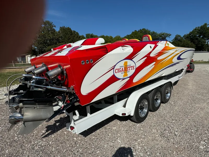 Slide: The Image of 2002 Cigarette 36 Gladiator speedboat with vibrant red and white design on a trailer. - 5