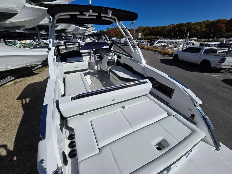 Slide: The Image of 2025 Cobalt R8 boat with spacious seating and sleek design in a marina setting. - 2