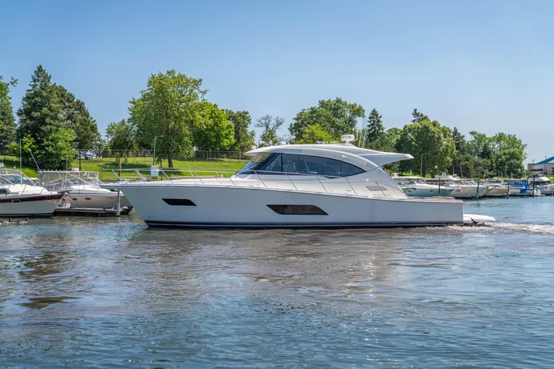 Slide: The Image of 2020 Riviera 525 SUV yacht cruising on a sunny day near a marina. - 12