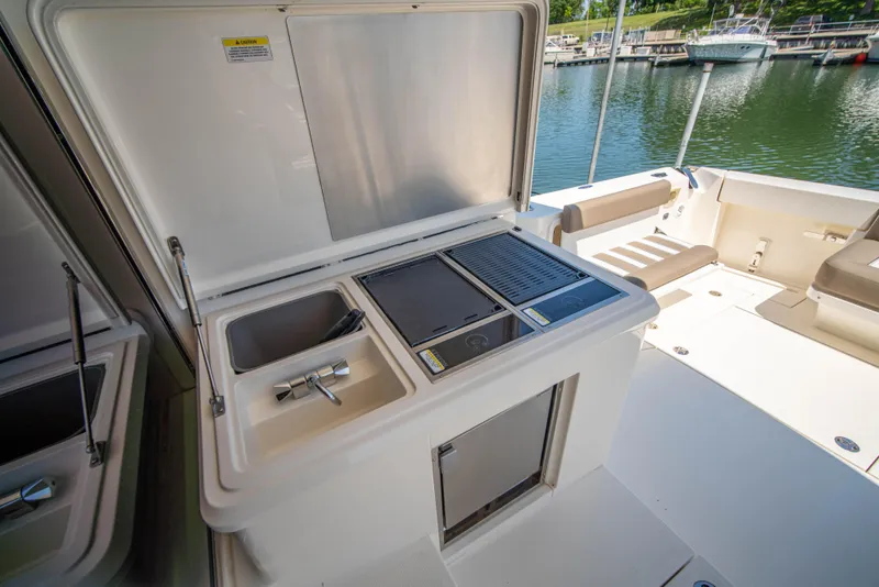 Slide: The Image of Riviera 525 SUV 2020 yacht with outdoor kitchenette and sink by the water. - 18