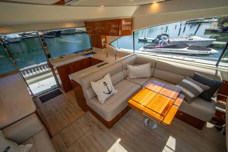 Slide: The Image of Luxurious 2020 Riviera 525 SUV interior with elegant seating and wooden table, docked at marina. - 31