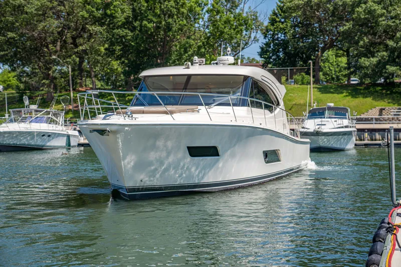 Slide: The Image of 2020 Riviera 525 SUV yacht cruising in a scenic marina setting. - 8