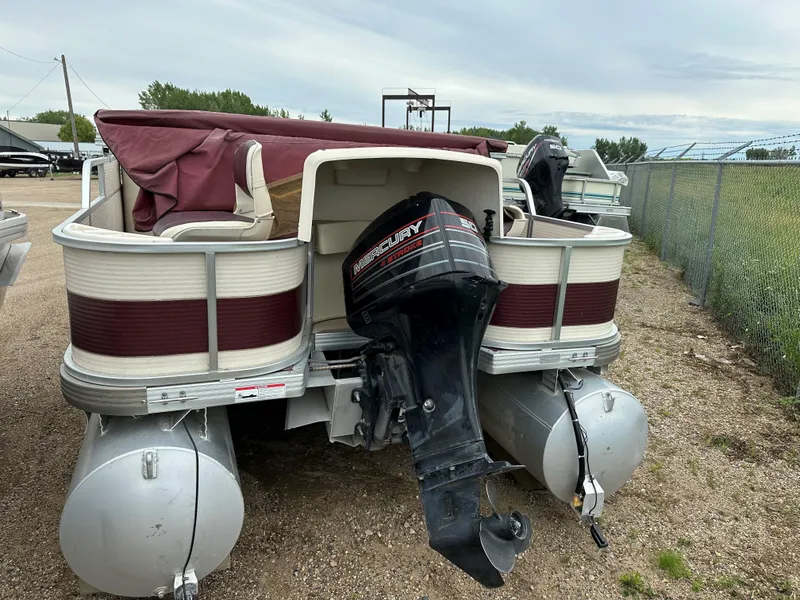 The Image of 1996 Premier ALANTE pontoon boat with Mercury outboard motor, parked on gravel. - 1