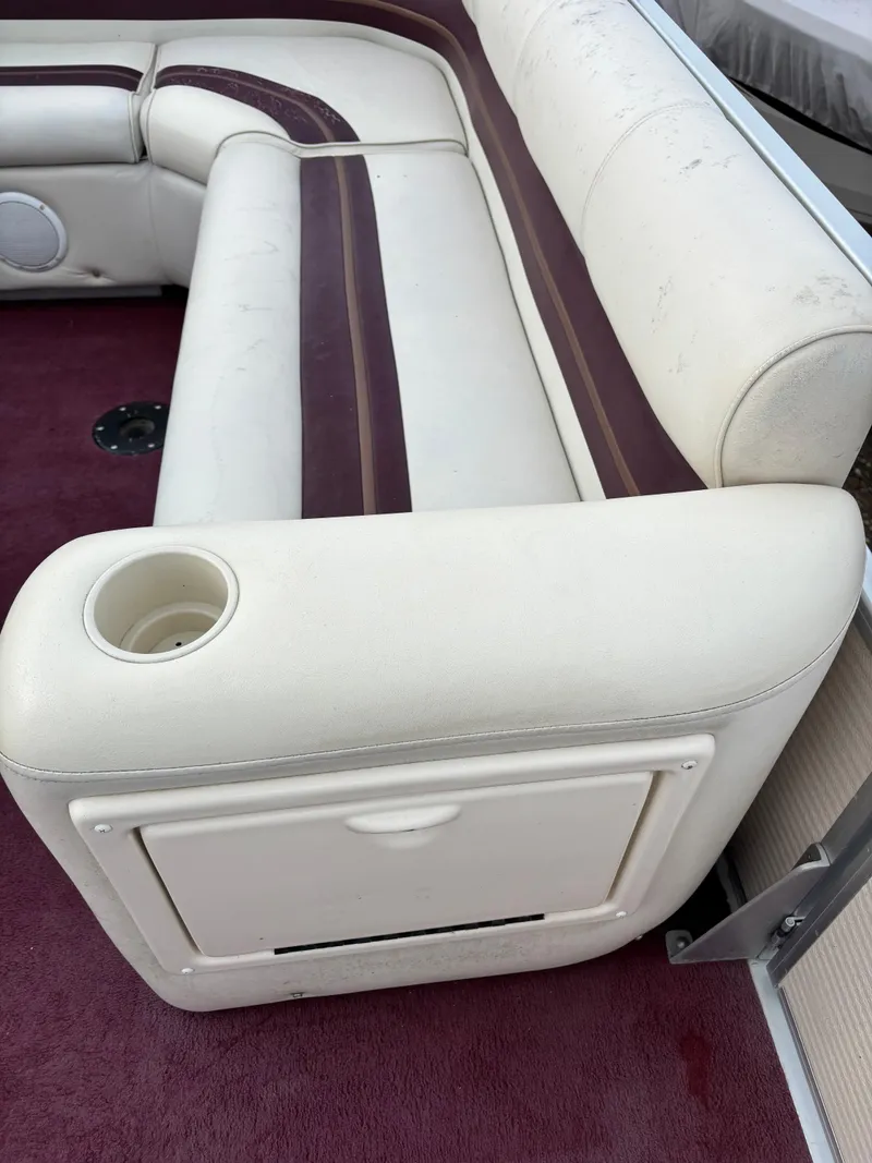 Slide: The Image of 1996 Premier ALANTE boat interior with white and maroon seating, cup holder, and storage compartment. - 14