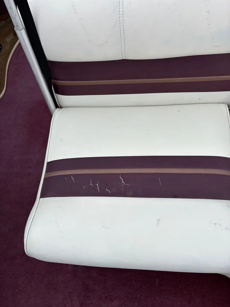Slide: The Image of 1996 Premier ALANTE boat seat with white and purple upholstery, showing signs of wear. - 15
