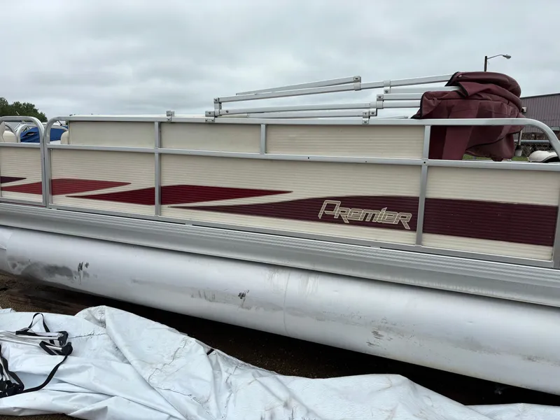 Slide: The Image of 1996 Premier ALANTE pontoon boat with maroon accents, docked on a cloudy day. - 20