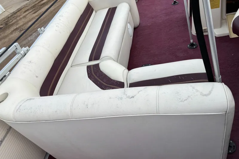 Slide: The Image of 1996 Premier ALANTE boat interior with white and maroon seating, showing signs of wear. - 21