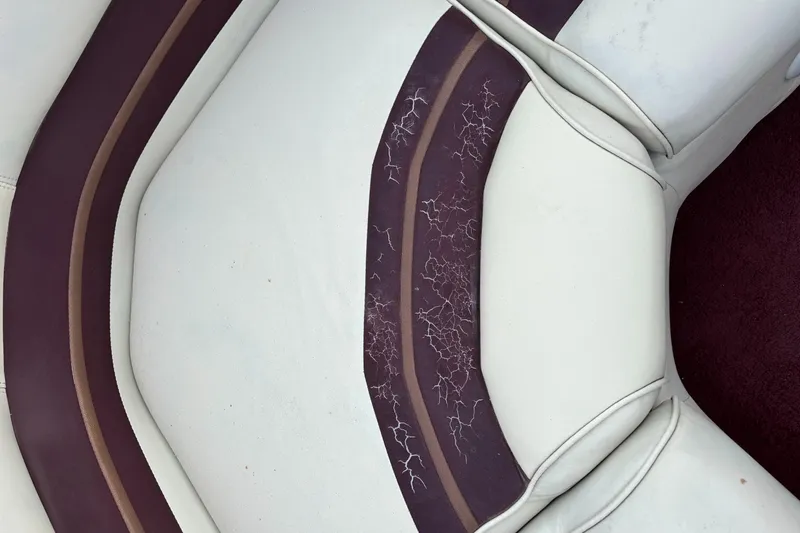 Slide: The Image of Cracked upholstery on 1996 Premier ALANTE boat seat, featuring white and maroon colors. - 22