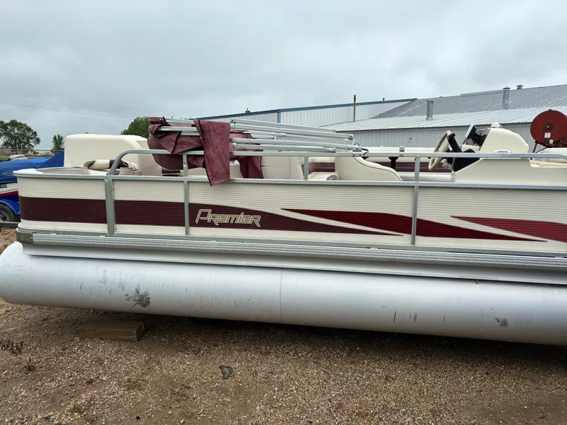 Slide: The Image of 1996 Premier ALANTE pontoon boat with maroon accents, parked on gravel. - 9