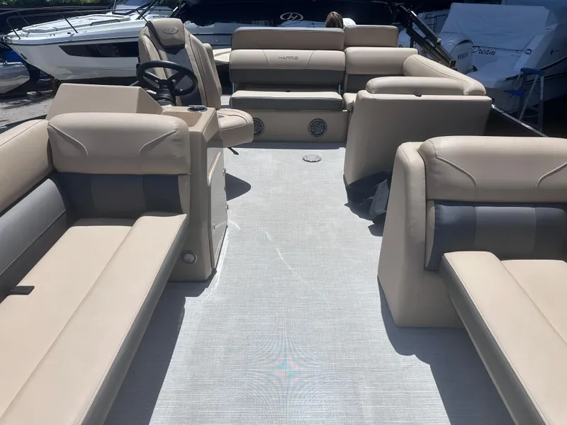 Slide: The Image of 2023 Harris Cruiser 230 boat interior with beige seating and steering wheel. - 14