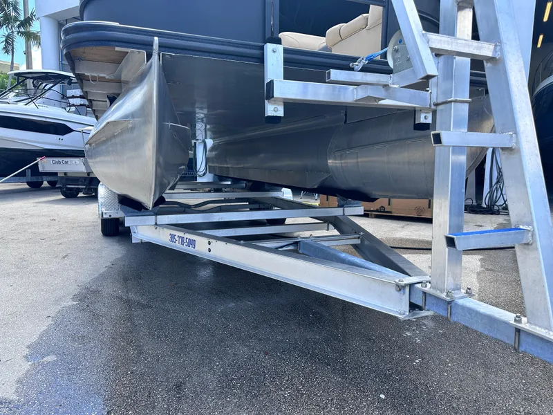 Slide: The Image of 2023 Harris Cruiser 230 pontoon boat on a trailer, showcasing its sleek design. - 23
