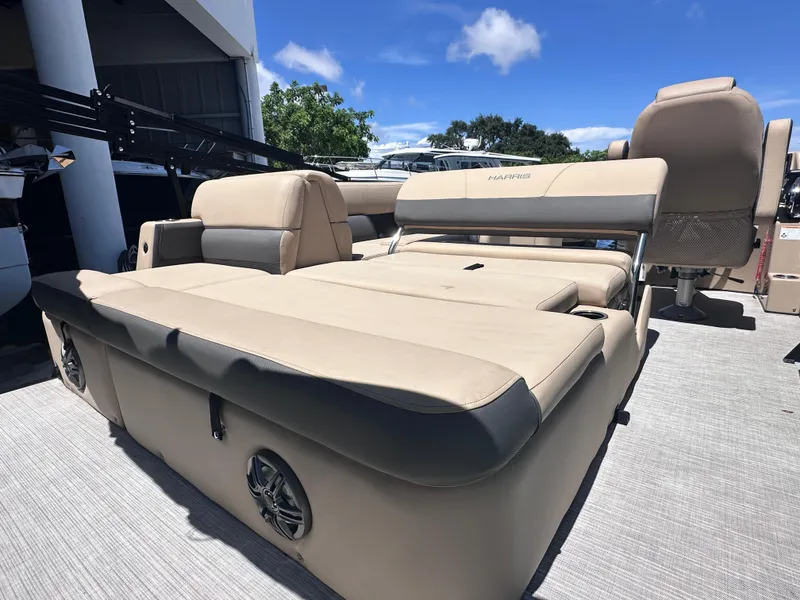 Slide: The Image of 2023 Harris Cruiser 230 boat interior with beige seating under a clear blue sky. - 3