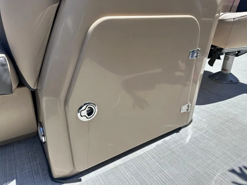 Slide: The Image of 2023 Harris Cruiser 230 storage compartment with beige finish and secure latch. - 7