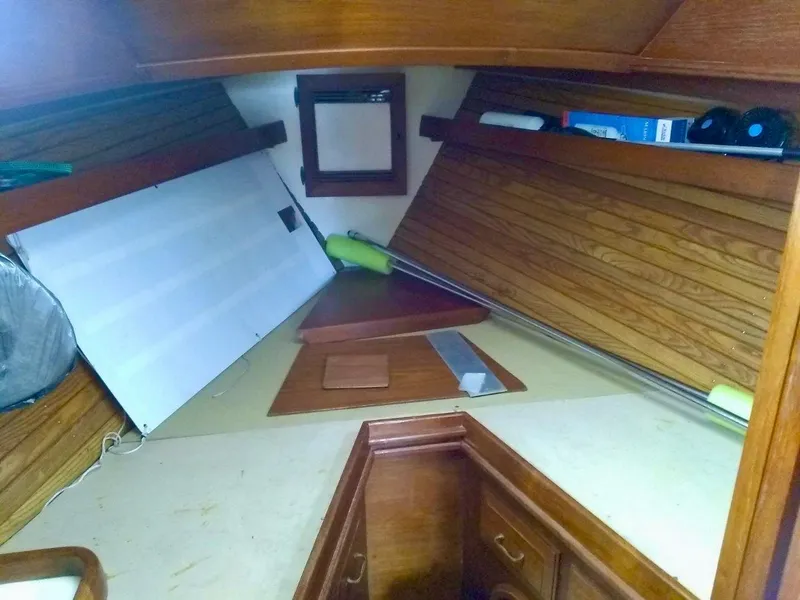 Slide: The Image of Interior of 1984 Cape Dory Cutter sailboat with wooden paneling and storage compartments. - 10