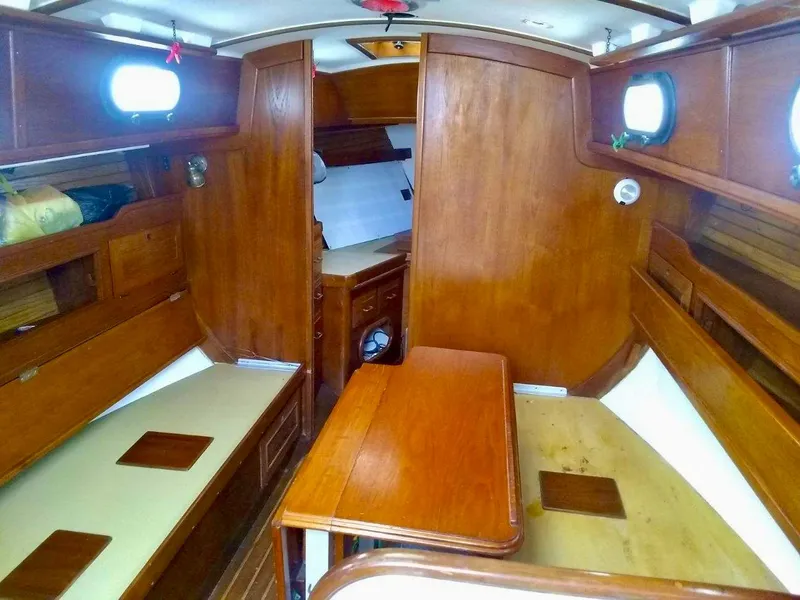 Slide: The Image of 1984 Cape Dory Cutter interior with wooden finish and cozy seating area. - 11